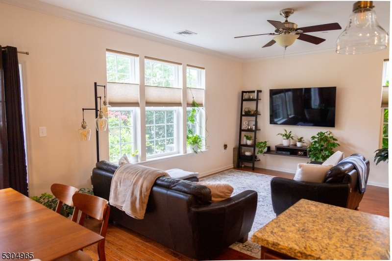 a living room with furniture a flat screen tv and a window