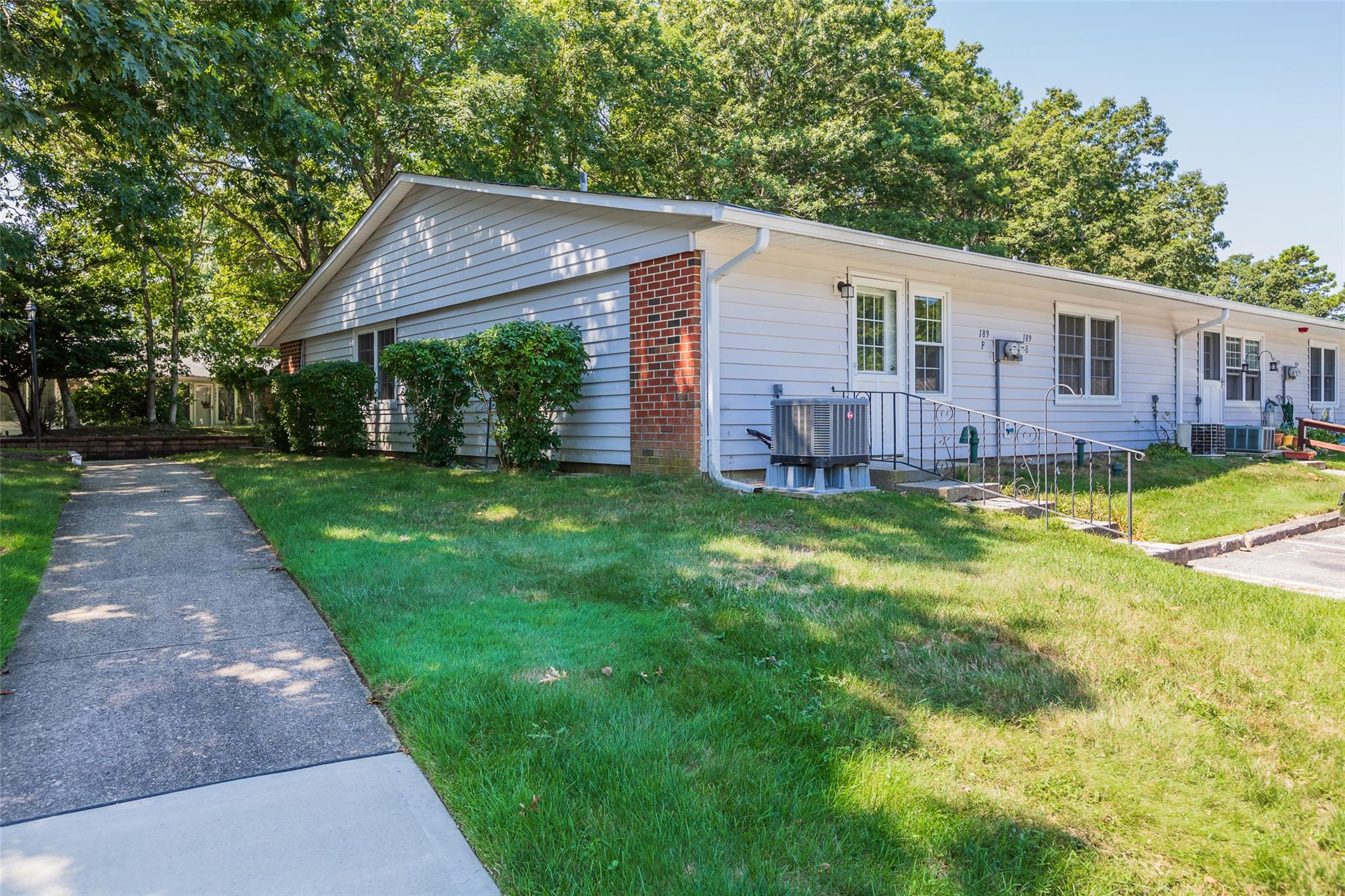 Single story home with a front lawn and cooling unit