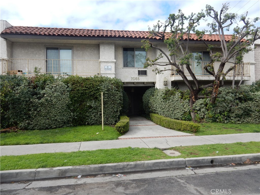 a front view of a house with a garden