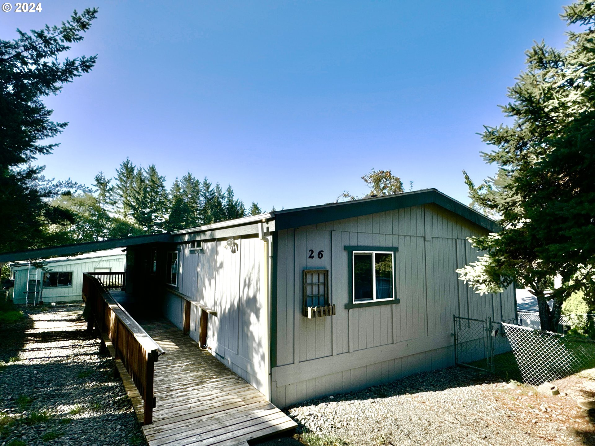 a view of a house with wooden fence next to a yard