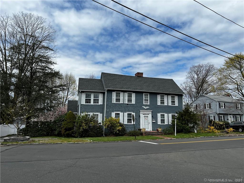 a view of a big house with a big yard and large trees