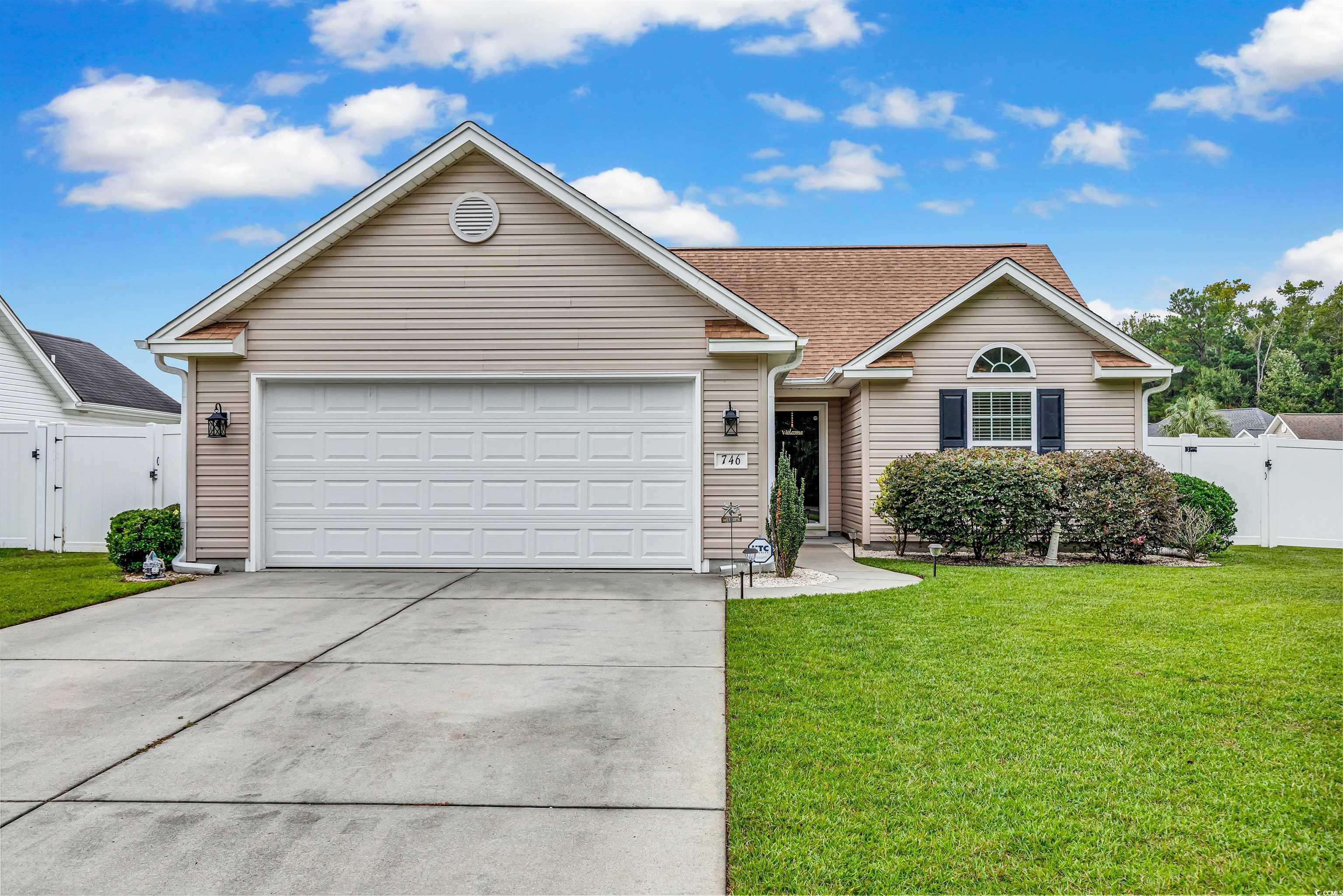 Ranch-style home featuring a front lawn and a gara