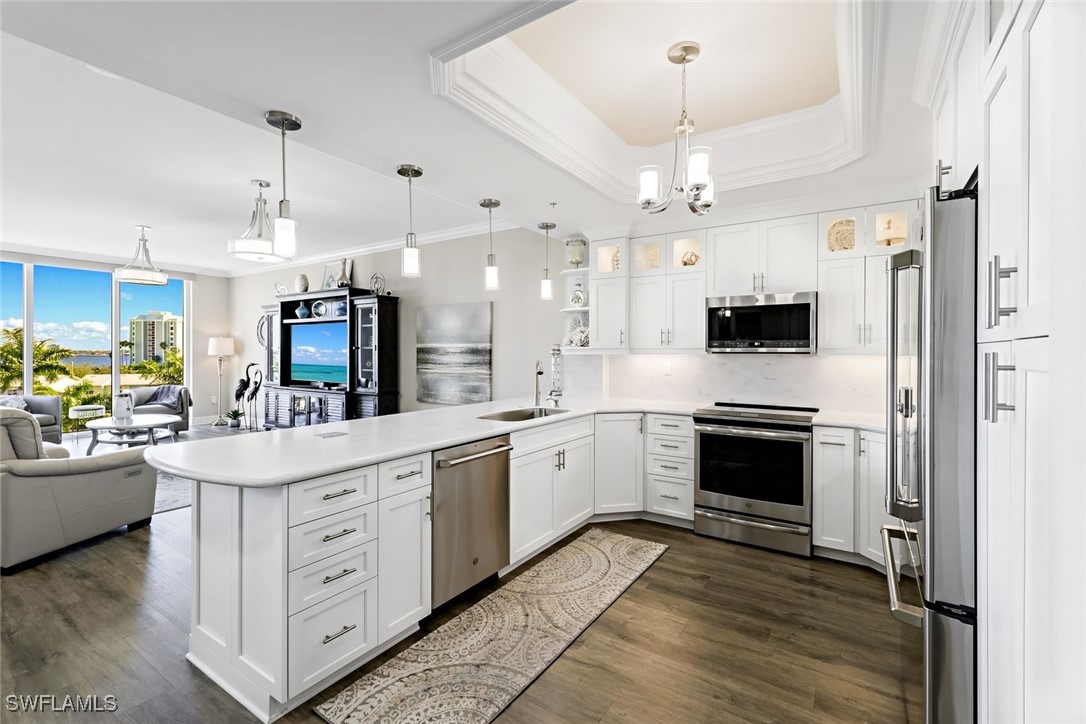 a large white kitchen with a stove top oven a refrigerator and a fireplace with wooden floor