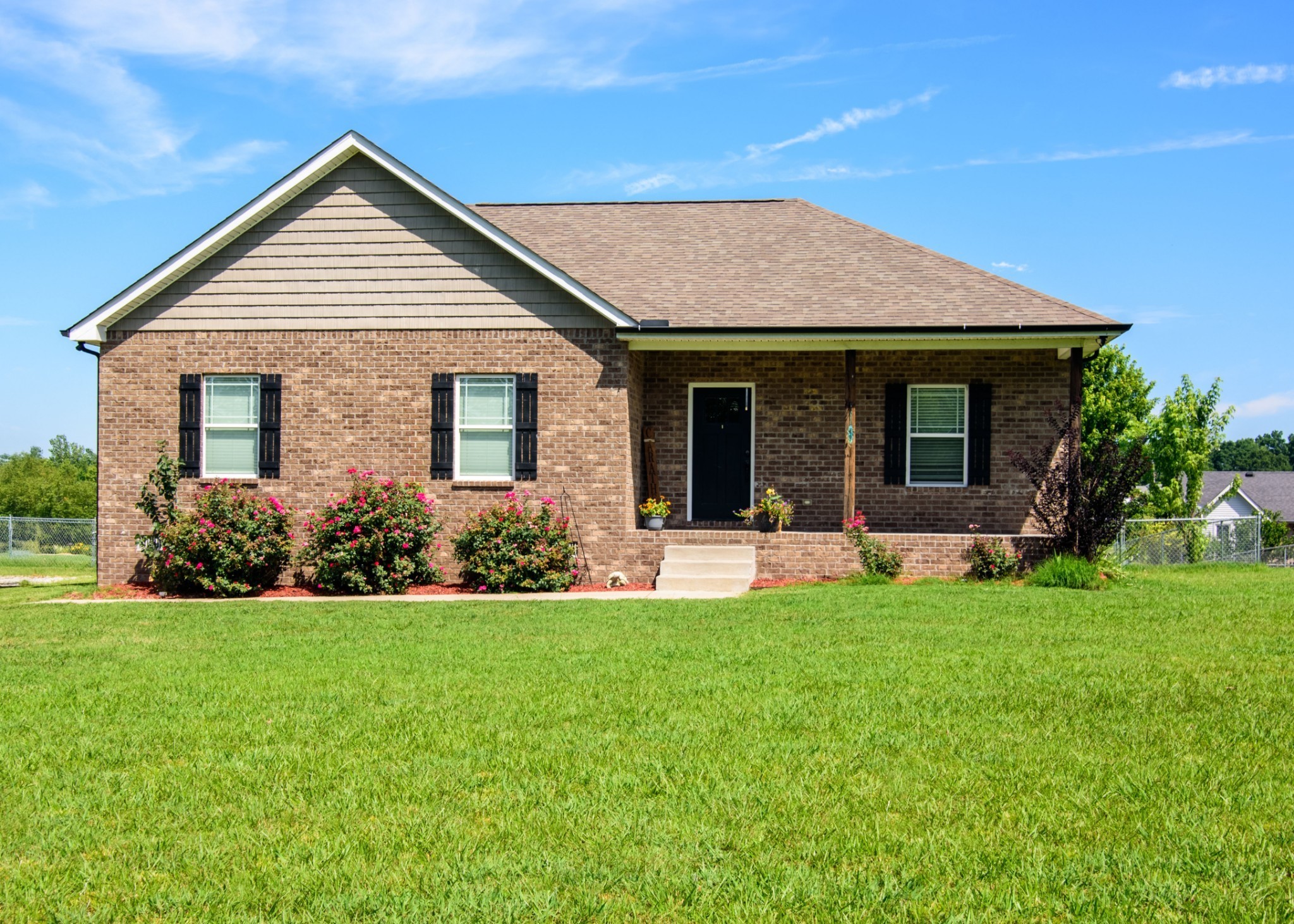 a view of a house with a yard and porch