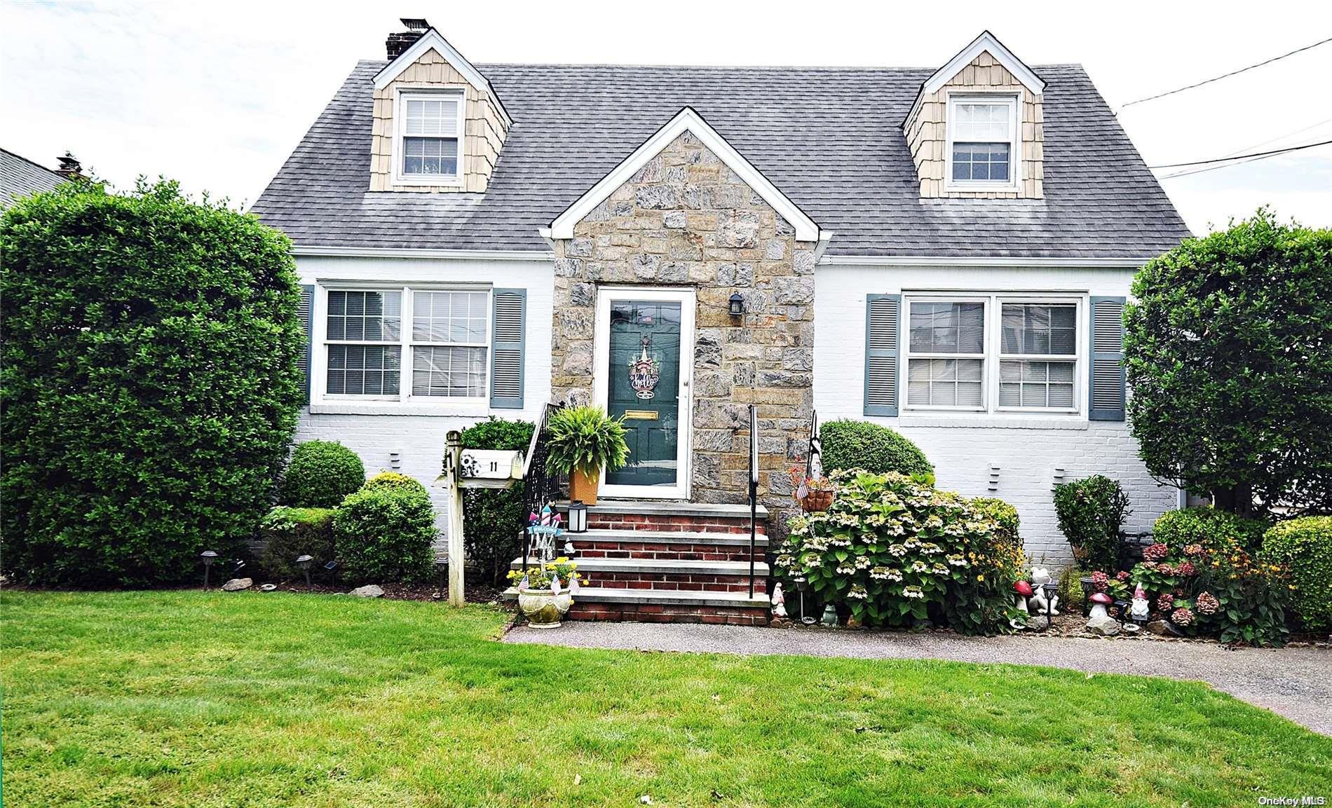 a front view of a house with a garden and yard