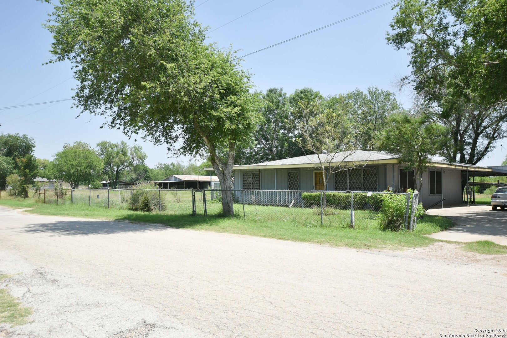 a view of a house with backyard and trees