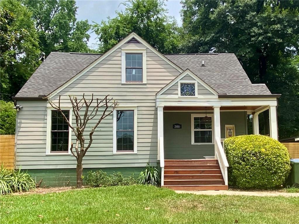 a front view of a house with a garden