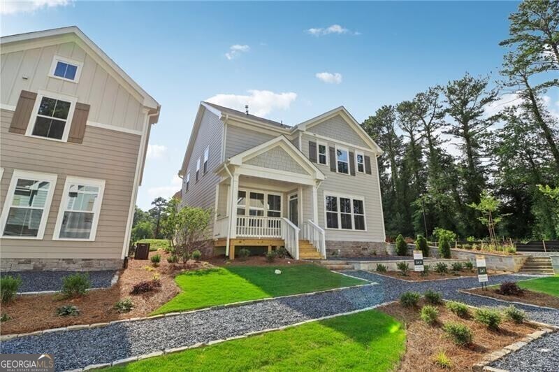 a front view of a house with garden and trees