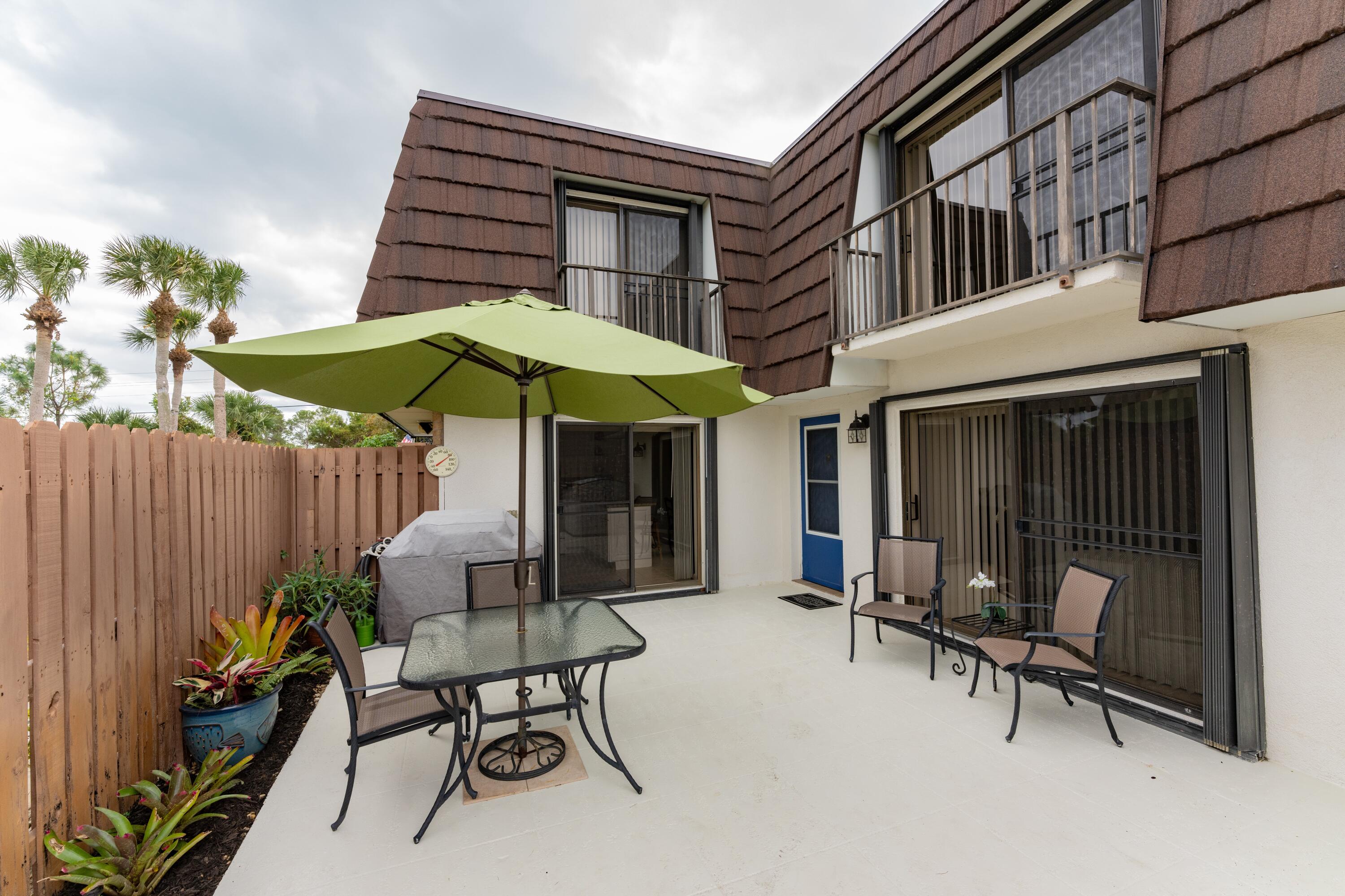 a patio with a table and chairs under an umbrella