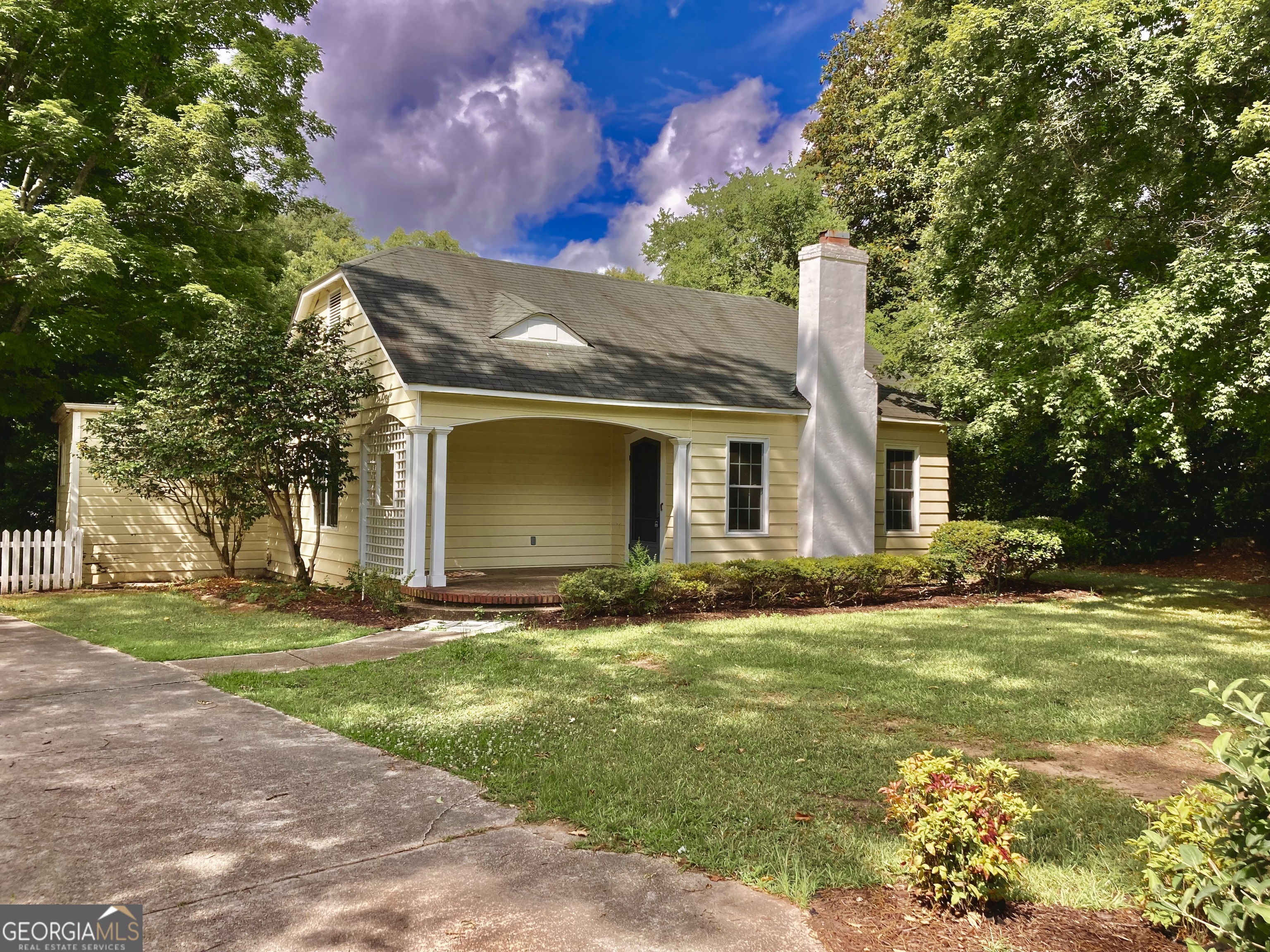 a view of a house with a yard and tree s