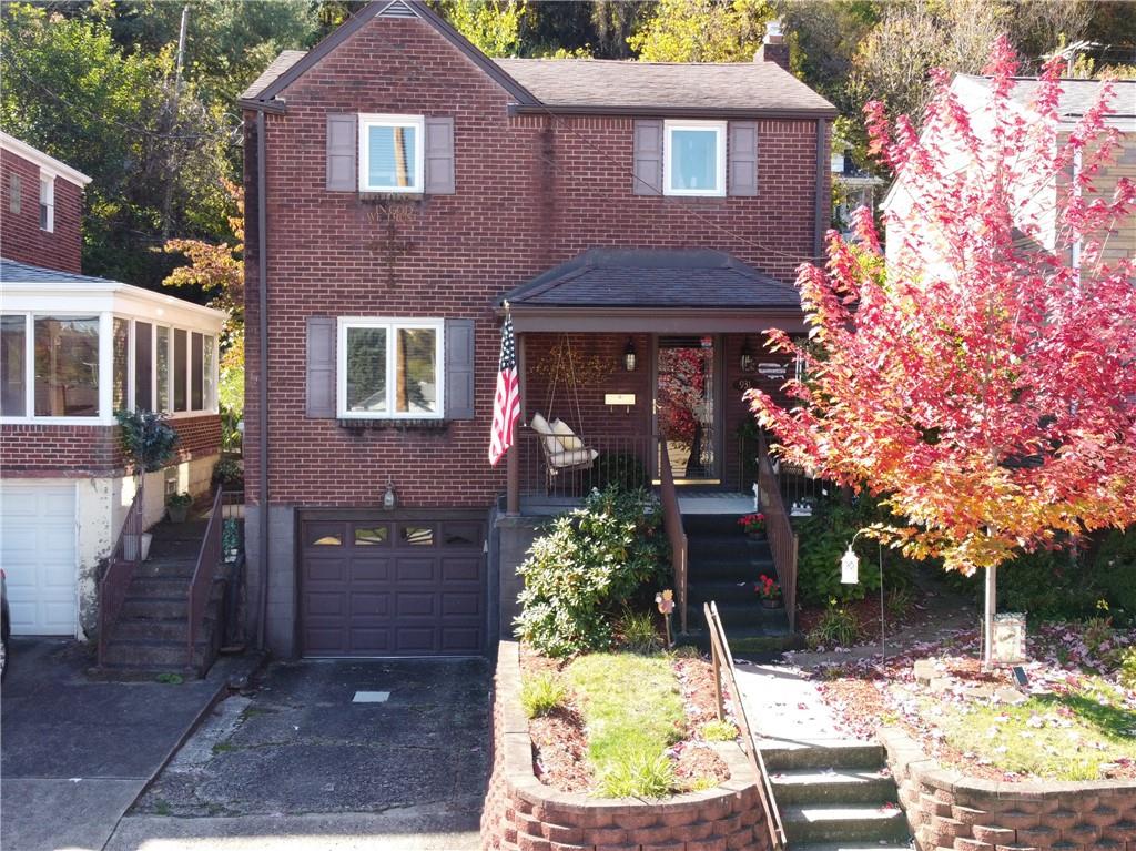 a view of a brick house with a yard and large tree