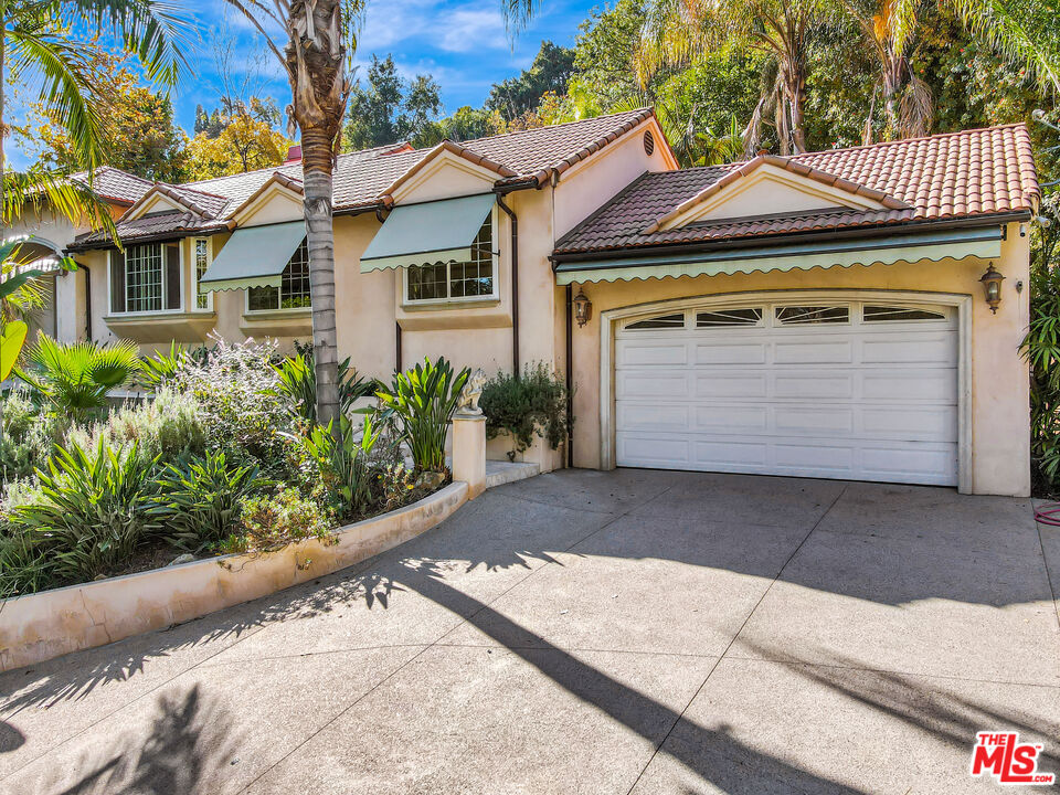 a front view of a house with a garden and garage