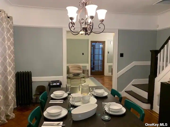 a dining room with furniture a chandelier and wooden floor