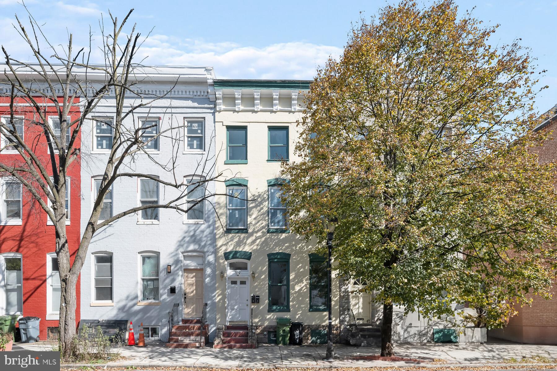 a front view of a building with large trees