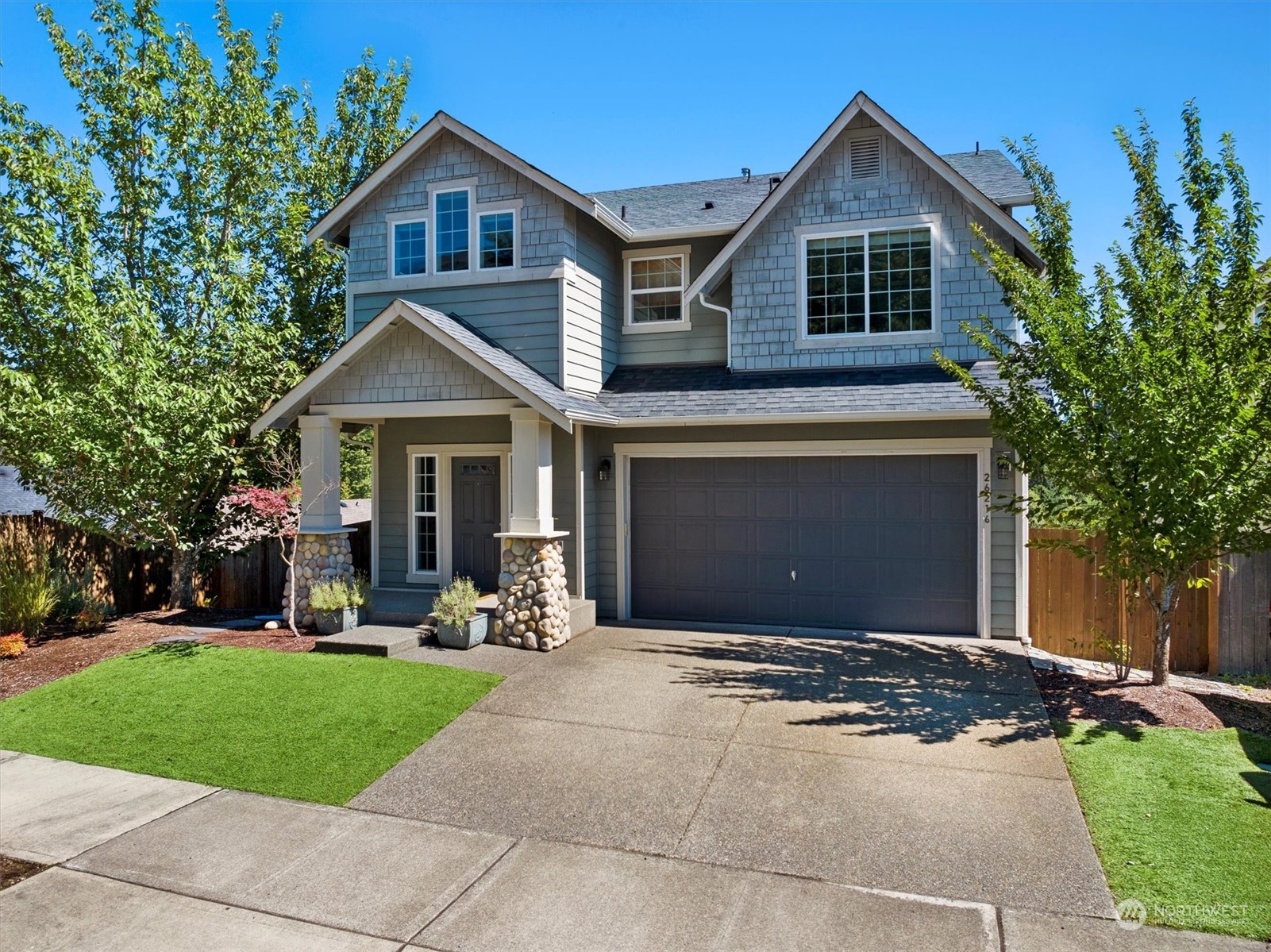 a front view of a house with a yard and trees