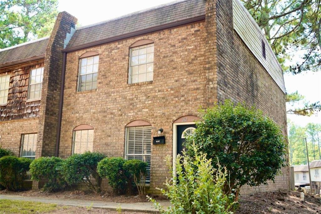 a view of a brick house with a large windows and plants