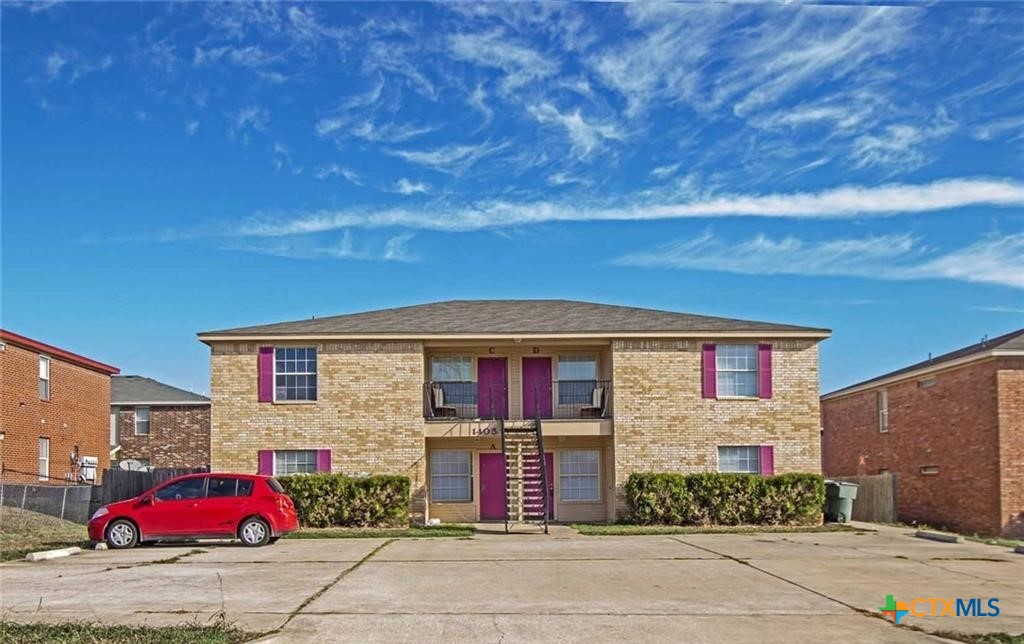 a front view of a house with cars