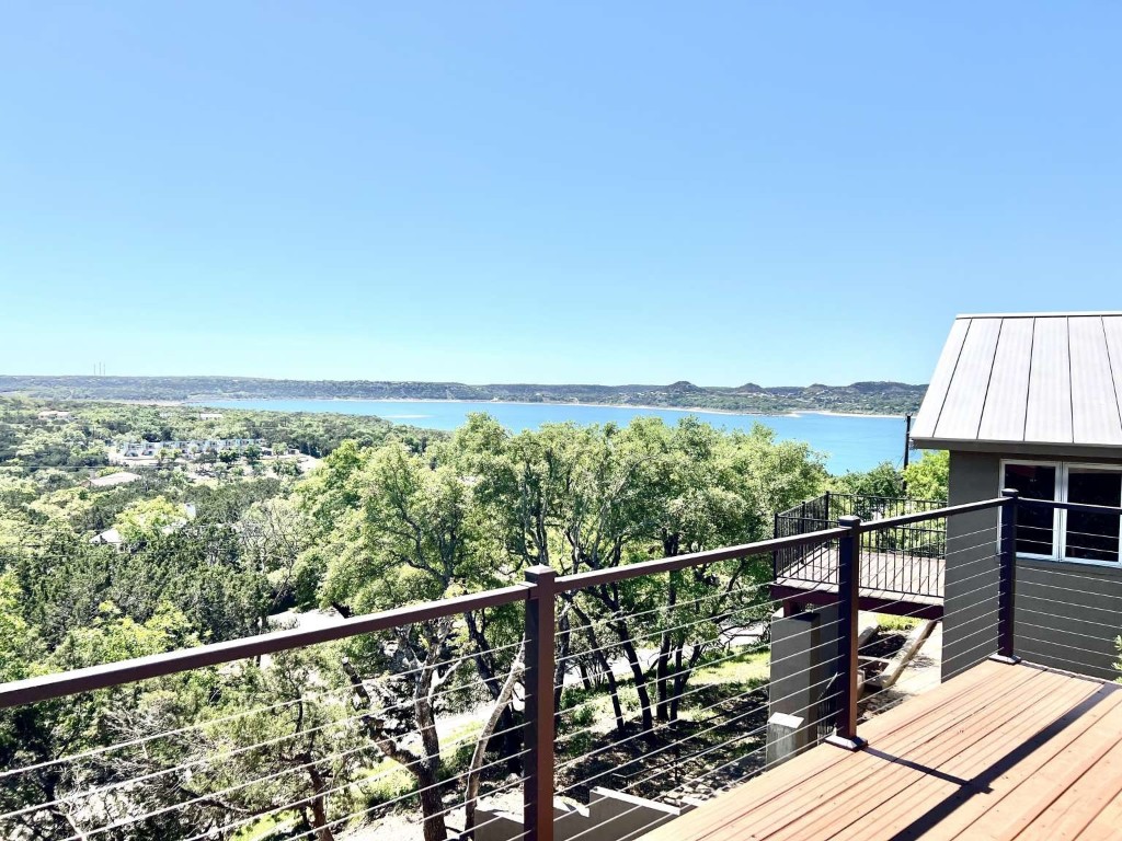 a view of a balcony with wooden floor and fence