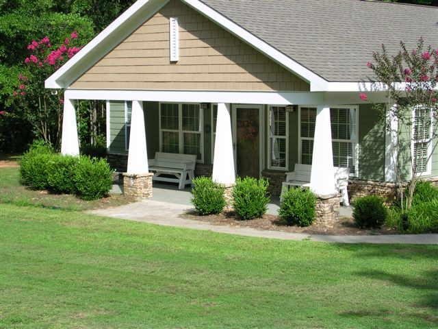 a front view of a house with a yard and potted plants