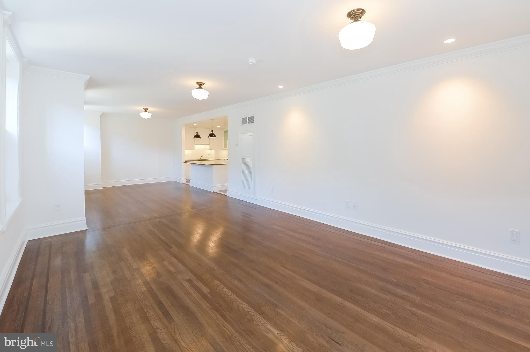 a view of a big room with wooden floor and windows