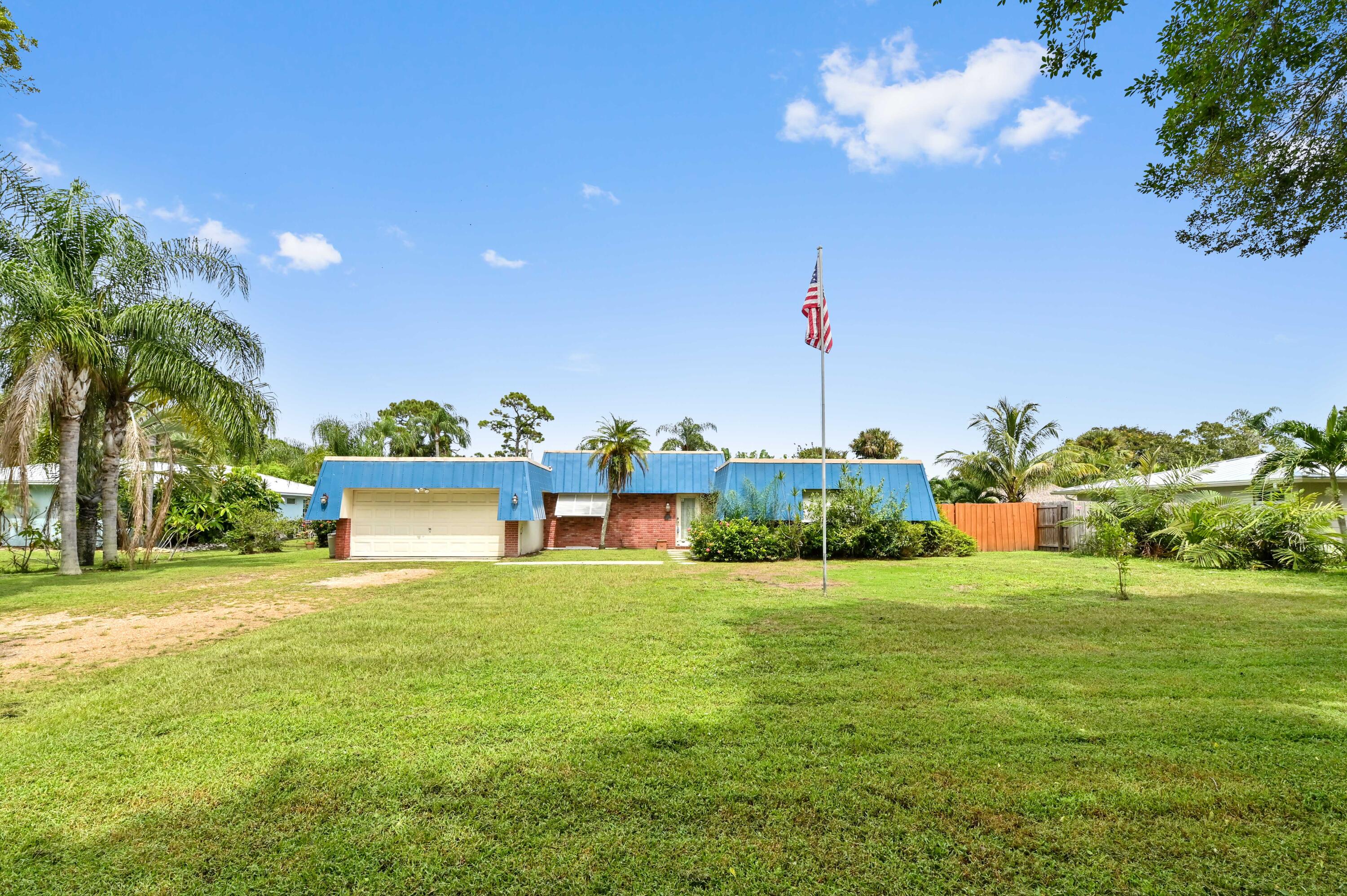 a view of a house with a big yard and potted plants