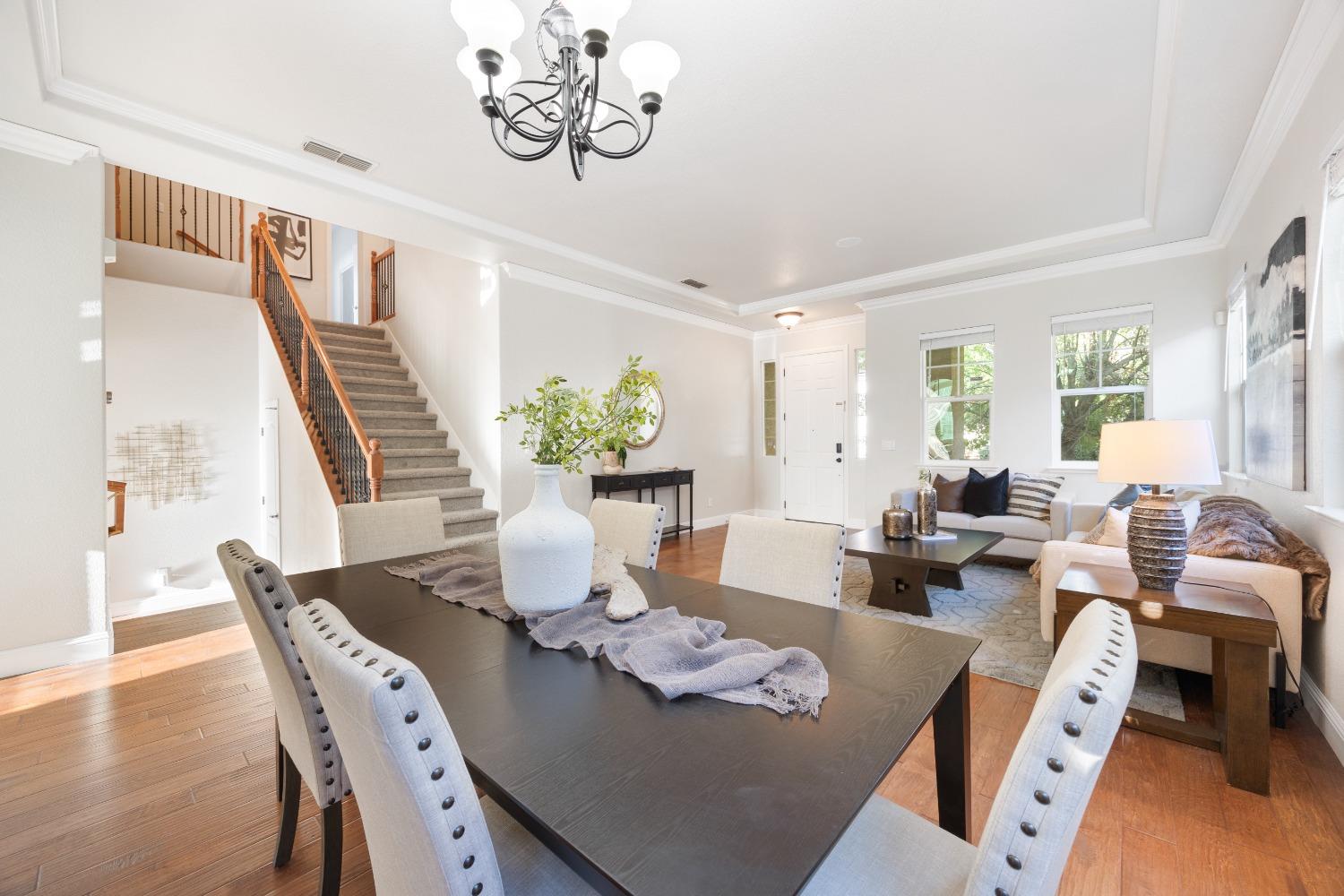 a view of a dining room with furniture a chandelier and wooden floor