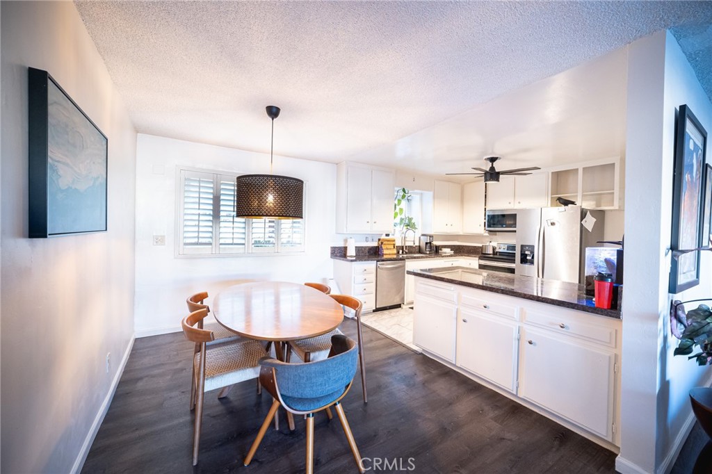 a kitchen with stainless steel appliances a dining table chairs and granite counter tops