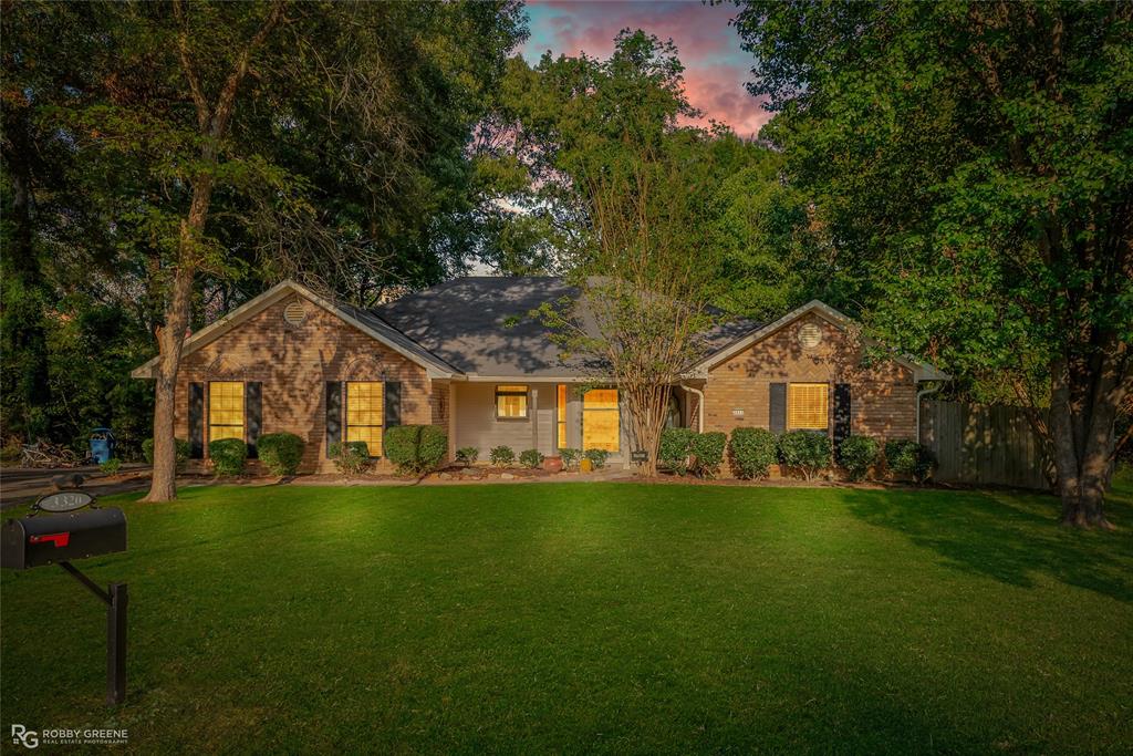 a front view of a house with a yard and trees