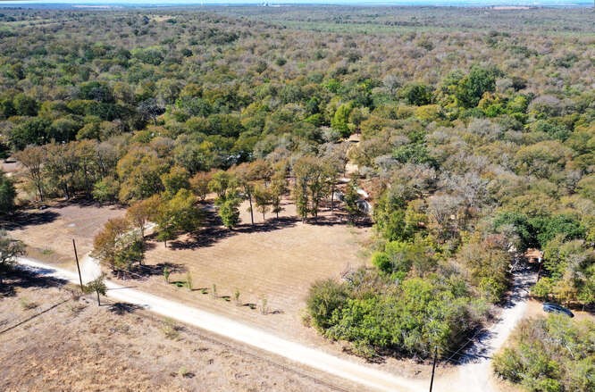 an aerial view of a house with a yard and covered with wooden fence