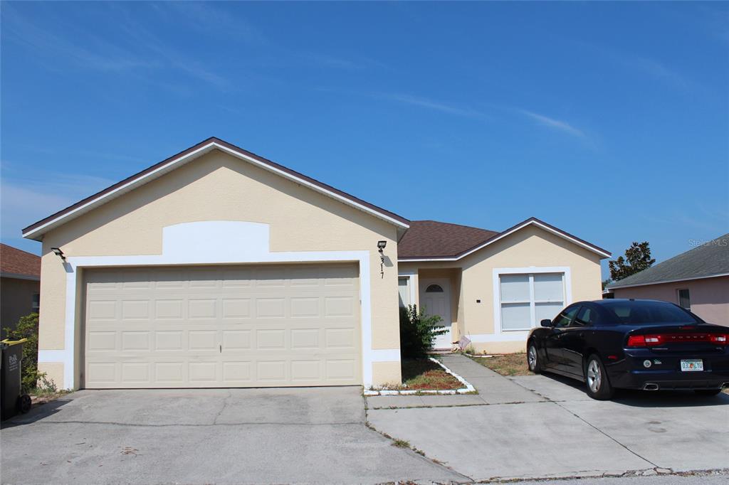 a view of house and car parked in front of house