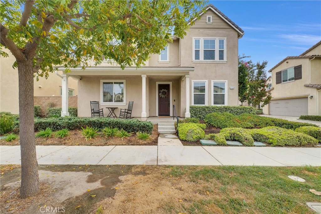 a front view of a house with a yard and potted plants