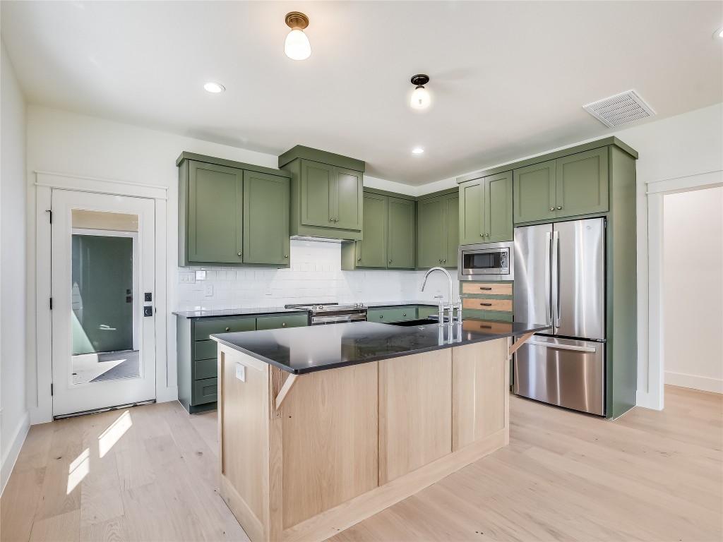 a kitchen with stainless steel appliances granite countertop a refrigerator and a stove