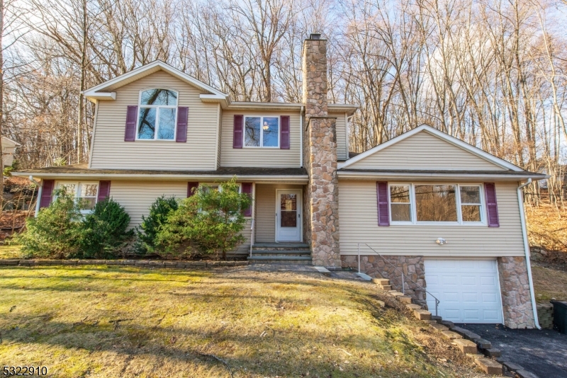 a front view of a house with a yard and trees