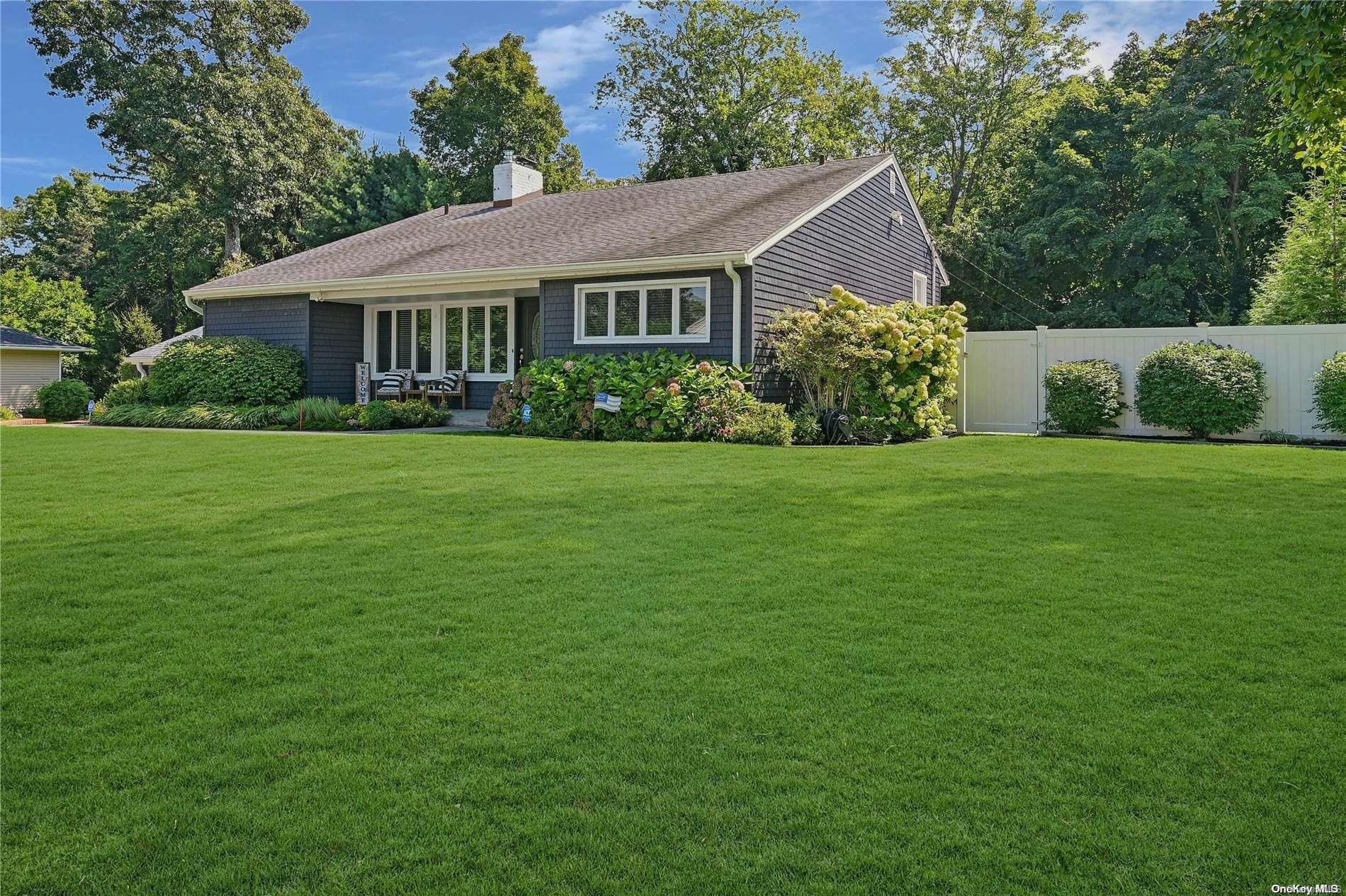 a front view of a house with a yard and trees