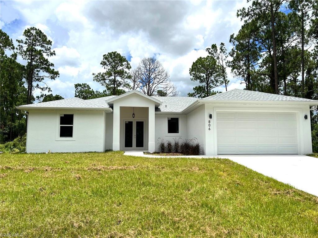 Single story home featuring a garage and a front lawn