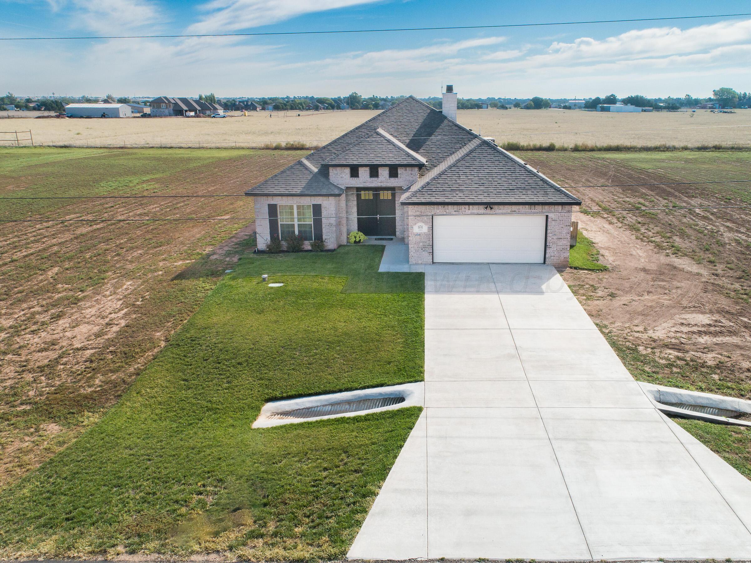 a aerial view of a house with a yard and lake view