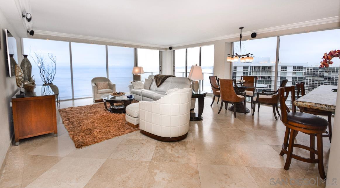 a living room with couches and a large window with kitchen view