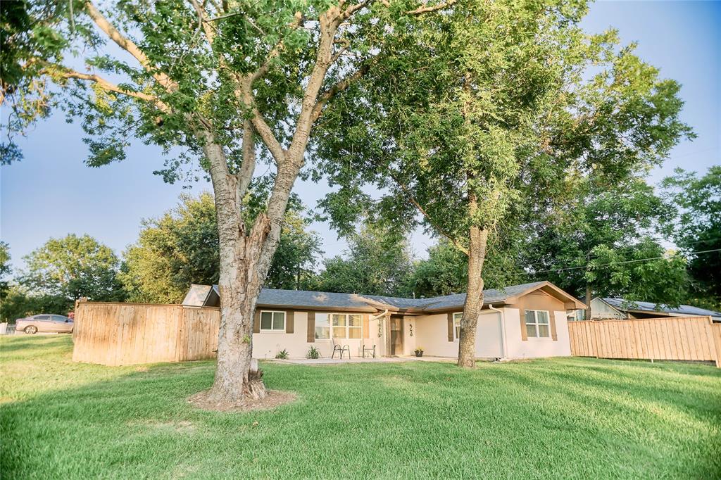 a front view of a house with a yard and trees