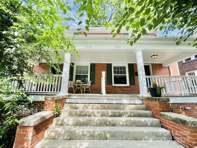 a front view of a house with plants and deck