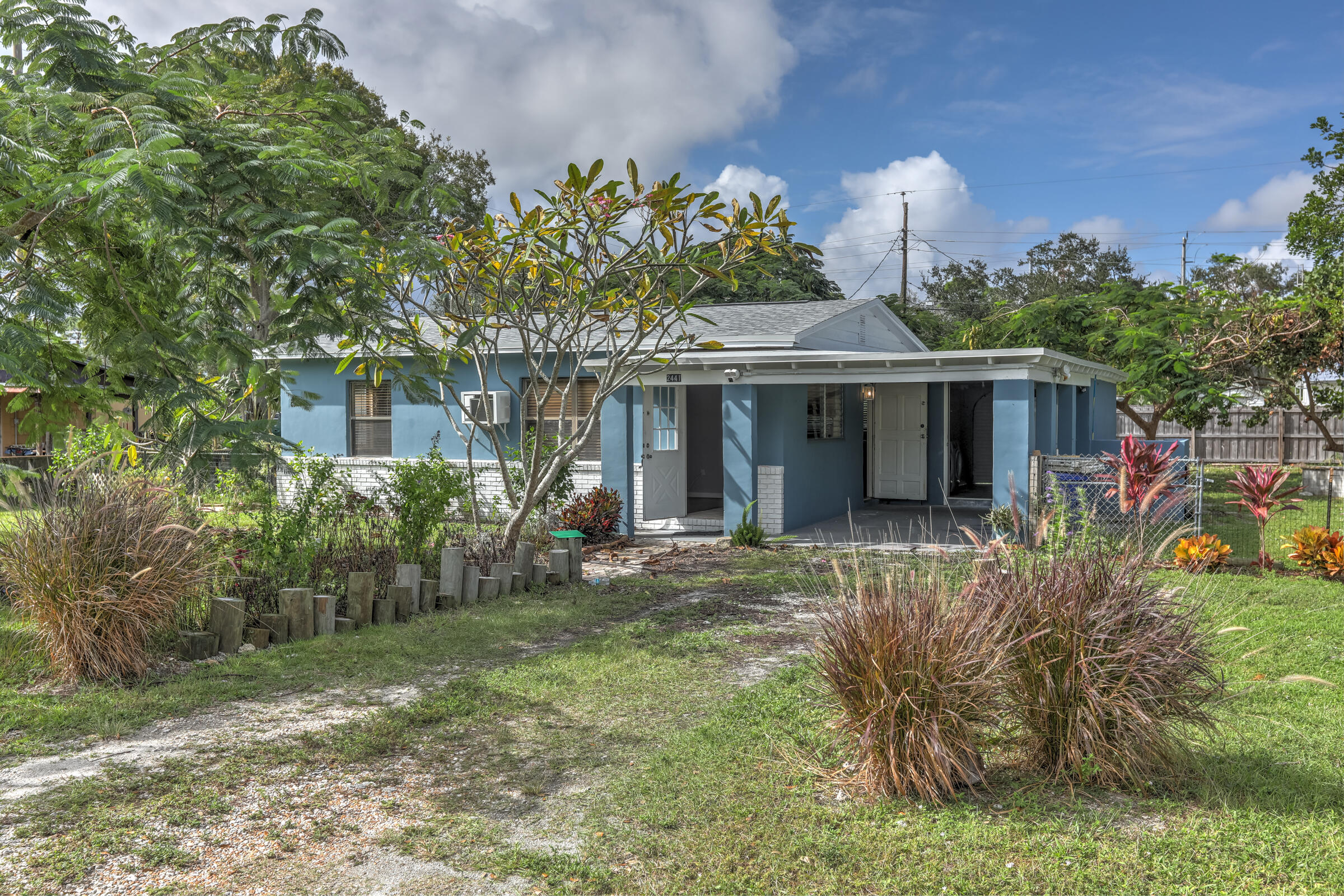 a front view of a house with a yard and potted plants