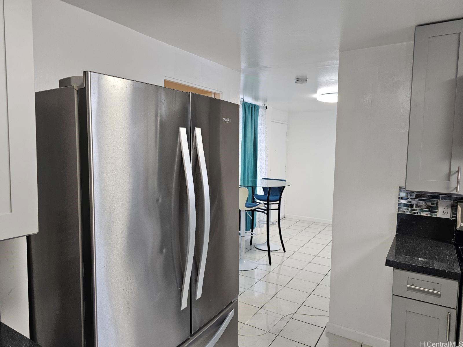 a metallic refrigerator freezer sitting in a kitchen