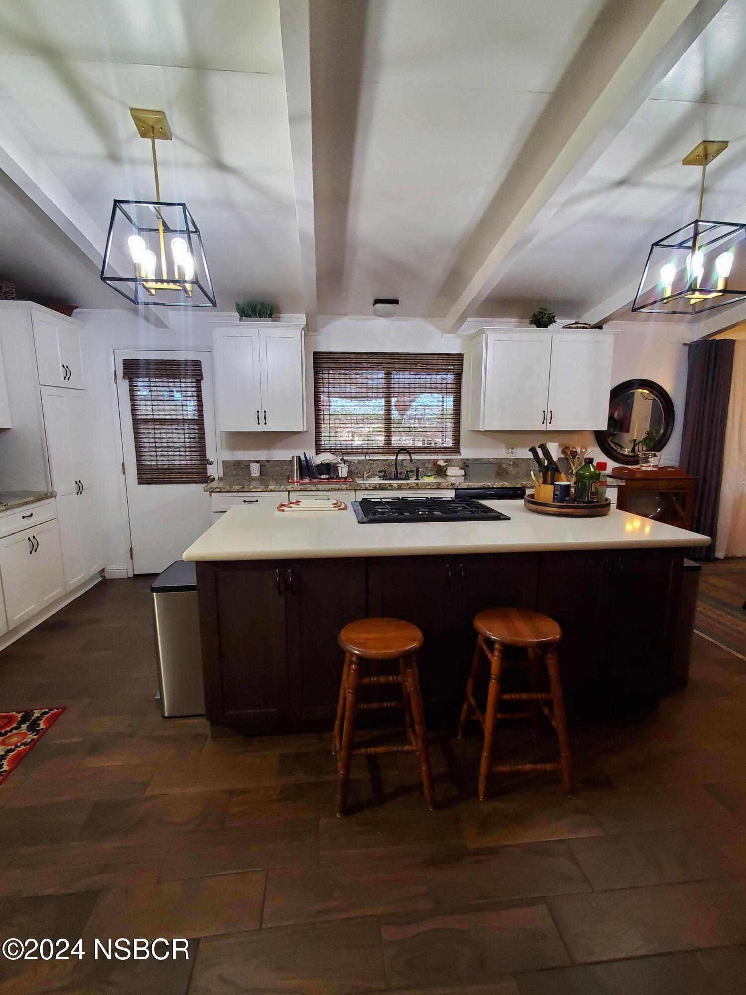 a kitchen with a sink cabinets and wooden floor