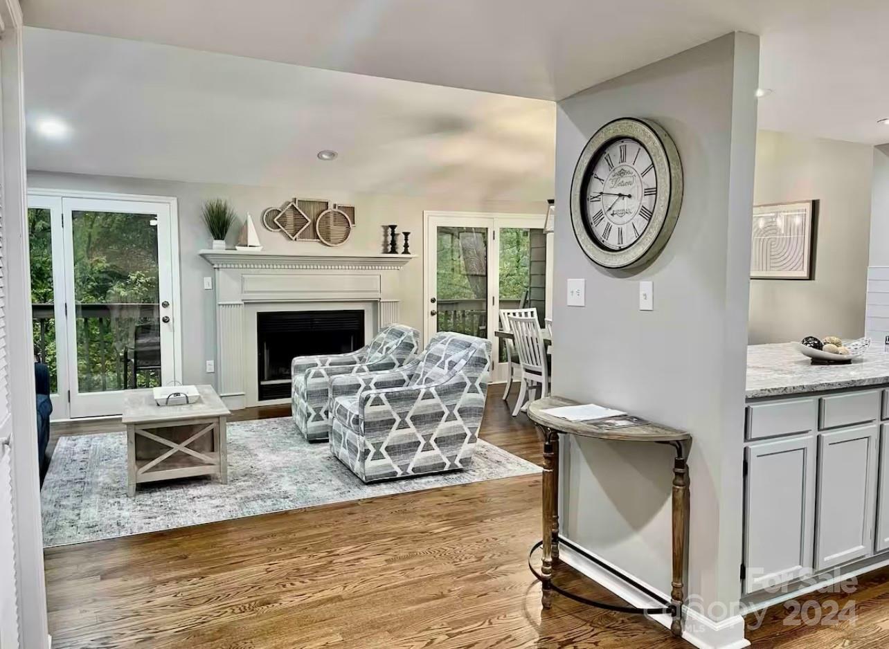 a living room with furniture a clock and a fireplace