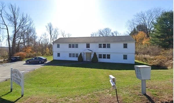 a view of house with yard and sitting area