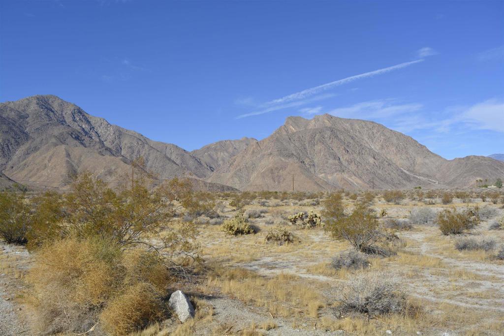 a view of a dry yard with mountains in the background