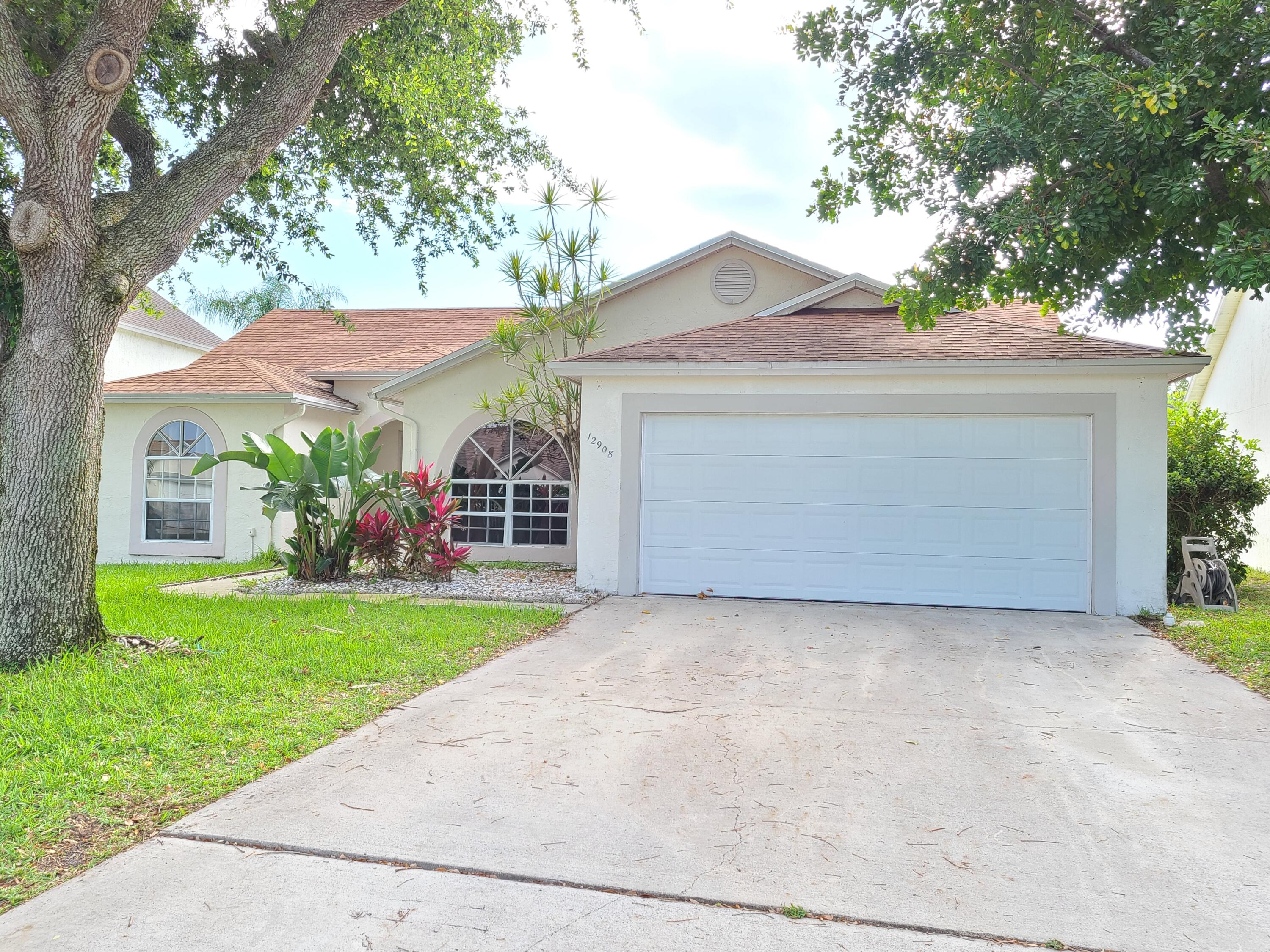 a view of a house with a yard and large tree