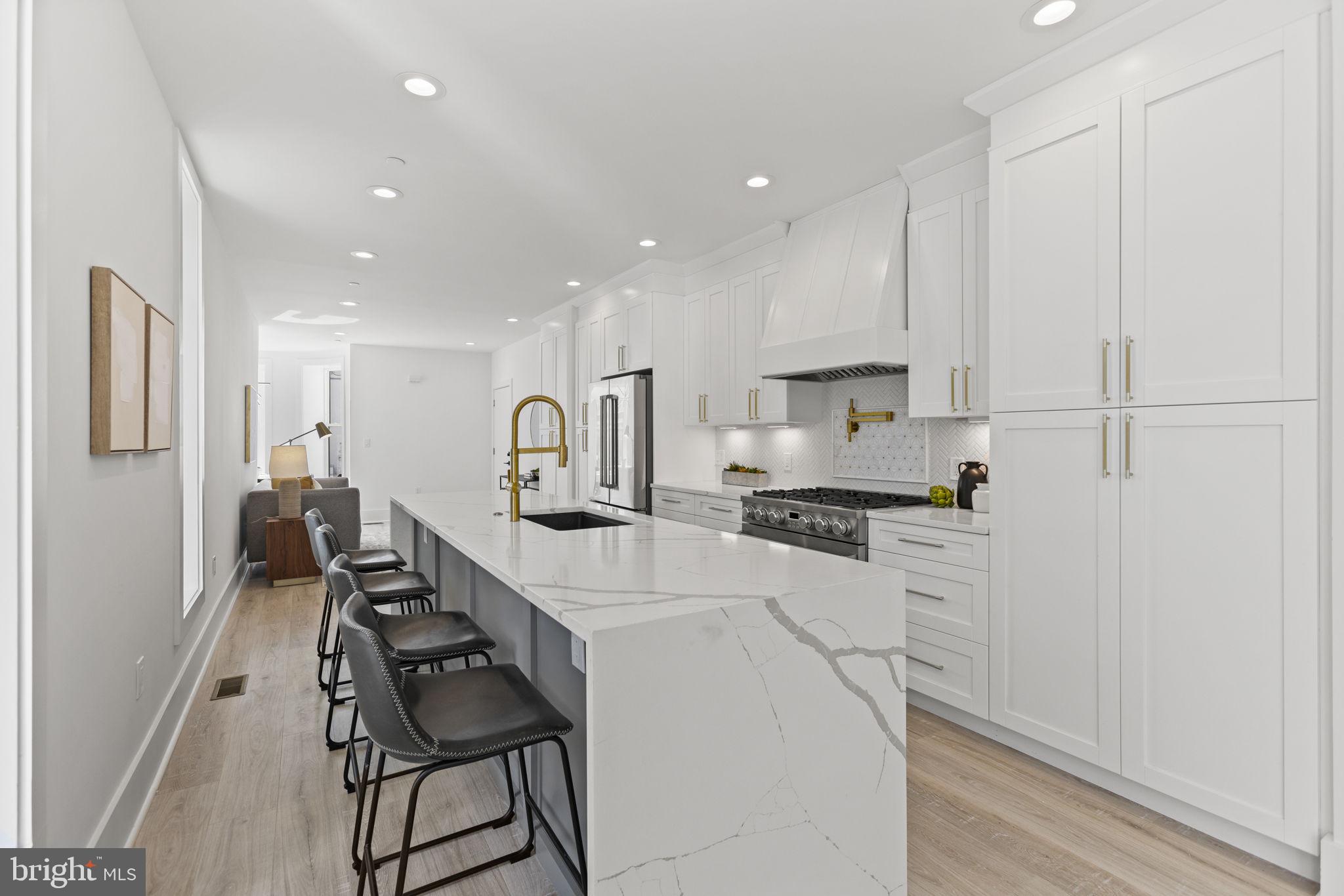 a kitchen with stainless steel appliances a sink a stove a refrigerator and cabinets