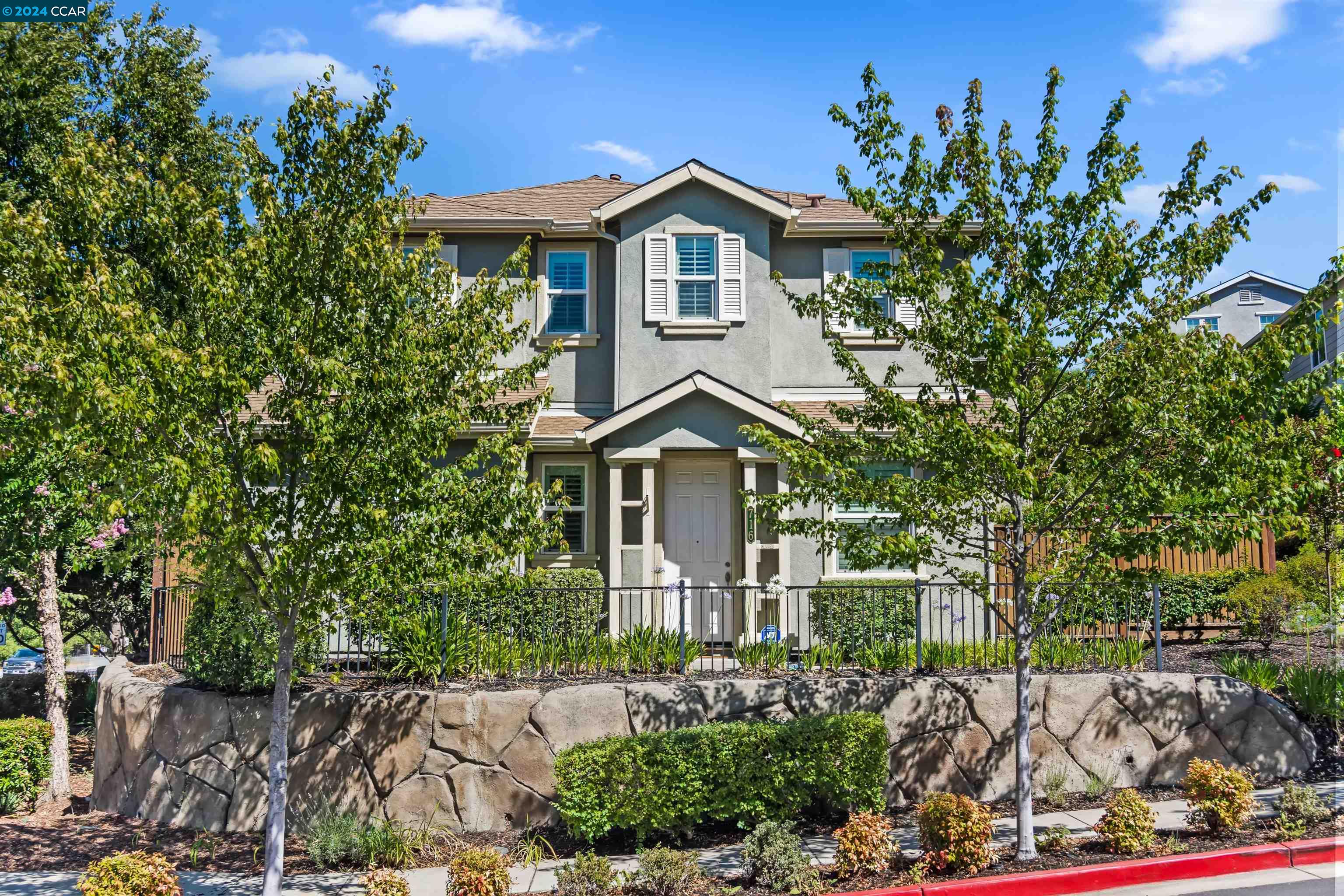 a front view of a house with a garden