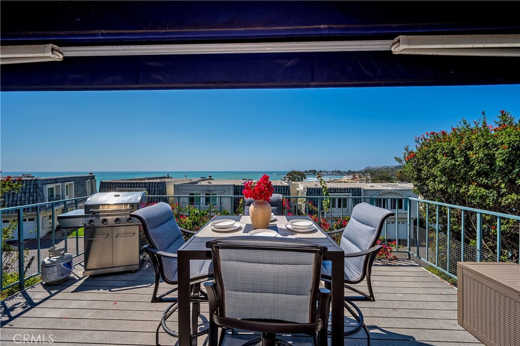 a view of a chairs and table on the roof deck