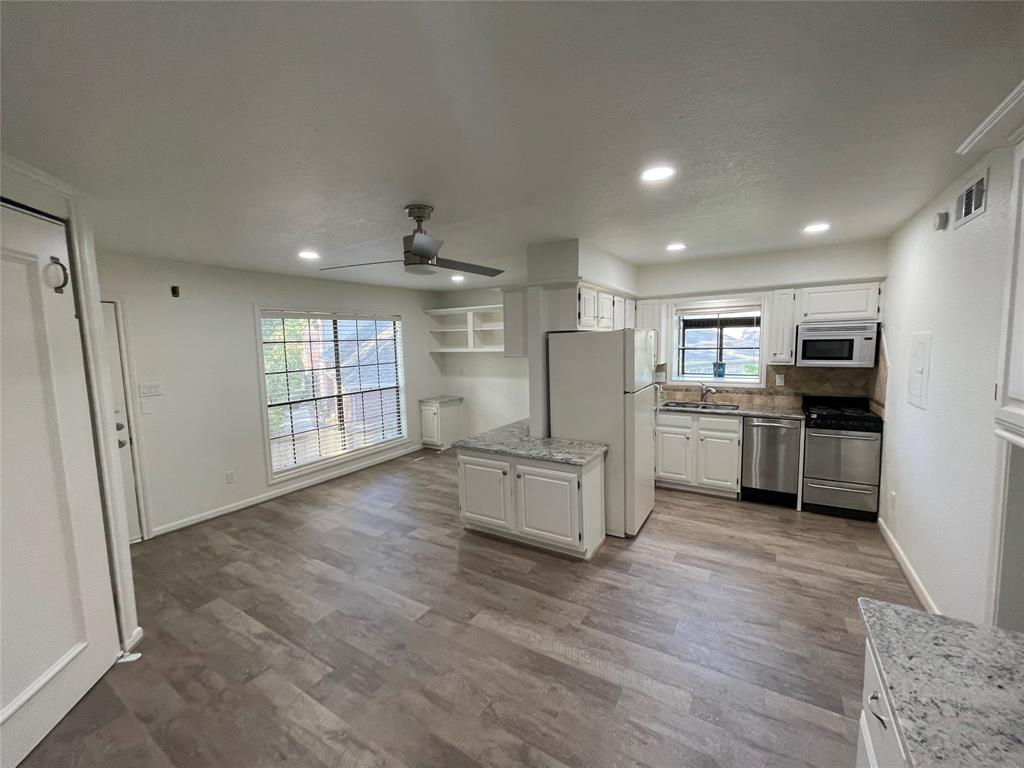 a kitchen with stainless steel appliances a refrigerator and a stove top oven